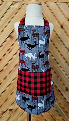 a mannequin wearing a red and black plaid apron with moose designs on it