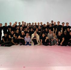 a group of men and women posing for a photo with a dog in front of them