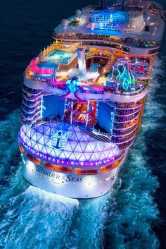 the royal princess cruise ship is lit up in blue and red lights at night, as seen from above