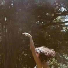 a young woman is throwing a frisbee in the park on a sunny day