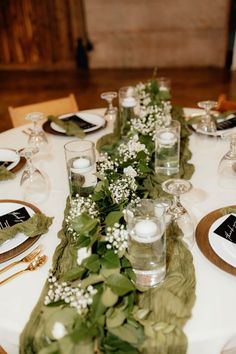 the table is set with candles and greenery for an elegant dinnereonal look