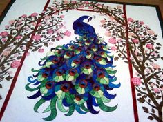 a quilt with a peacock and flowers on it