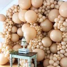 a room filled with balloons and a cake on top of a table next to a wall