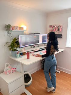 a woman standing in front of a computer desk