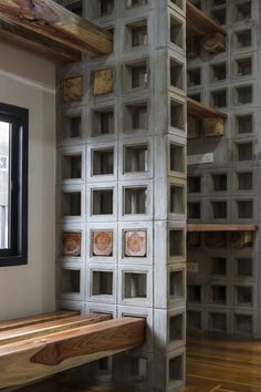 a wooden bench sitting in front of a wall made out of bookshelves and shelves