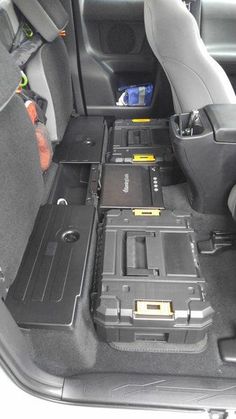 the back seats of a car with laptops and other electronic equipment in it's compartment