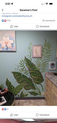 an instagram photo of someone's room with a painting on the wall and palm leaves painted on the wall