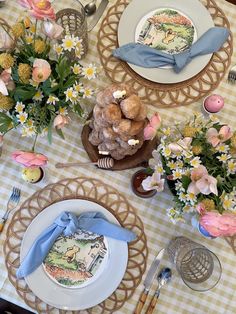 the table is set with flowers, plates and utensils