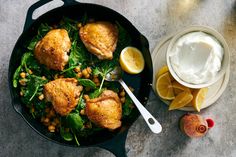 chicken and chickpeas in a skillet with yogurt on the side