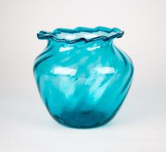 a blue glass vase sitting on top of a white table