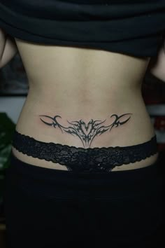 a woman's lower back tattoo with three birds on the side and an intricate lace belt