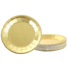 a stack of gold plates sitting next to each other on top of a white surface