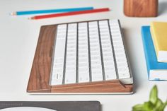 a computer keyboard sitting on top of a desk next to a mouse and notebooks