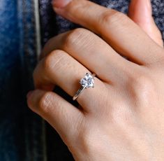 a woman's hand with a diamond ring on it