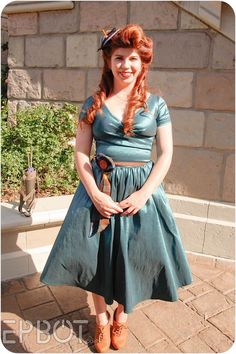 a woman with red hair wearing a blue dress