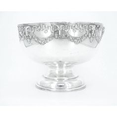 a large silver bowl with ornate designs on the rim and sides, set against a white background