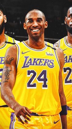 three lakers players standing next to each other in front of a basketball court with the number 24 on it