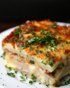 a white plate topped with lasagna covered in cheese