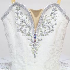 the back of a white wedding dress with beading and sequins on it