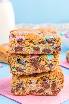 three chocolate chip cookie bars stacked on top of each other next to a glass of milk