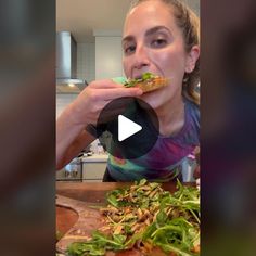 a woman is eating pizza in the kitchen