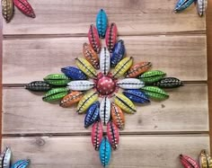 multicolored metal flowers on wooden planks are featured in this artistic art work