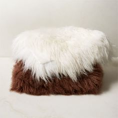 a brown and white furry pillow sitting on top of a table