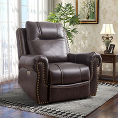 a brown recliner chair sitting on top of a rug in front of a window