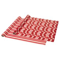 a red and white placemat with leaves on it, sitting on top of a table