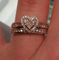 a close up of a person's hand with two wedding rings