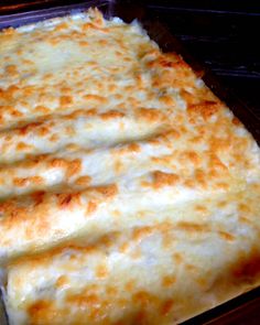 chicken enchiladas with sour cream white sauce in a casserole dish