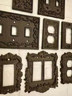 four ornate switchplates and two plates on a white brick wall