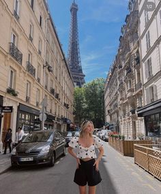 a woman standing in front of the eiffel tower with her hands on her hips