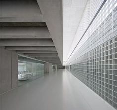 an empty room with glass blocks on the walls and floor, in front of a concrete wall