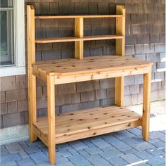 a wooden shelf sitting on the side of a house next to a brick wall and door