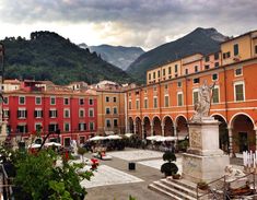 the town square is surrounded by mountains and buildings