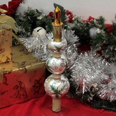 This 12.00 Inch 3 Tiered Holly Lace Tree Topper Is Made In The Czech Republic. This Multi-Tiered Finial Is Decorated With Thick Frosting Like Glitter In The Shape Of Leaves. The Leaves Are Outlined With Green Glitter Scrolling And 3 Red Gem-Like Stones. In Between Each Tier Is A Band Of Pewter Glitter That Matches The Pewter Colored Candle With A Gold Colored Flame.. 12 In H X 2.75 In W X 2.75 In D. Purchase includes 1 Tree Topper. Christina's World, Lace Candles, Lace Trees, Coloured Candles, Pewter Color, Candle Tree, Tree Topper, Green Glitter, Tree Toppers