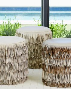 two stools made out of grass sitting on top of a white floor next to a window