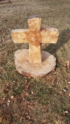 a wooden cross sitting on top of a tree stump