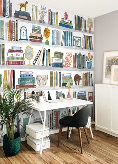 a room with bookshelves filled with lots of different types of books on the wall