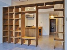 an empty room with wooden shelves and open doors