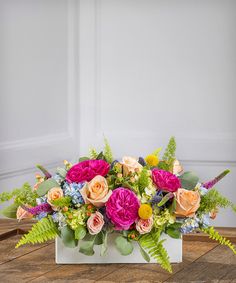 an arrangement of colorful flowers in a white vase