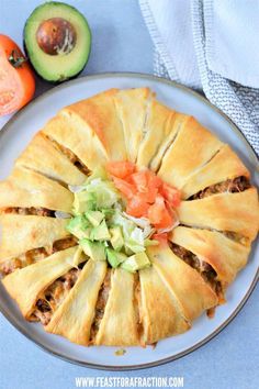 a white plate topped with food next to an avocado