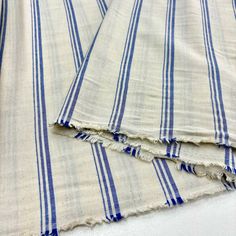 two blue and white striped towels laying on top of each other