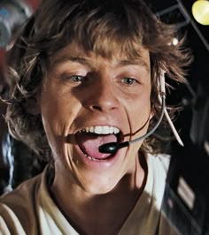 a young man wearing a star wars costume is making a goofy face with his tongue out