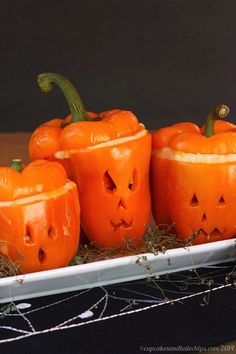 four carved pumpkins on a white plate