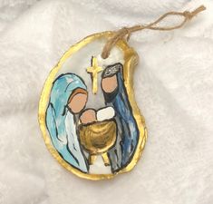 an ornament with a painting of the birth of jesus on it's side