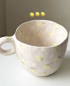 a white cup with lemons floating out of it