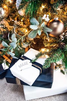 presents under the christmas tree are wrapped in black and white paper with personalized tags