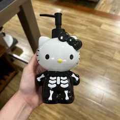 a hello kitty skeleton soap dispenser in someone's hand